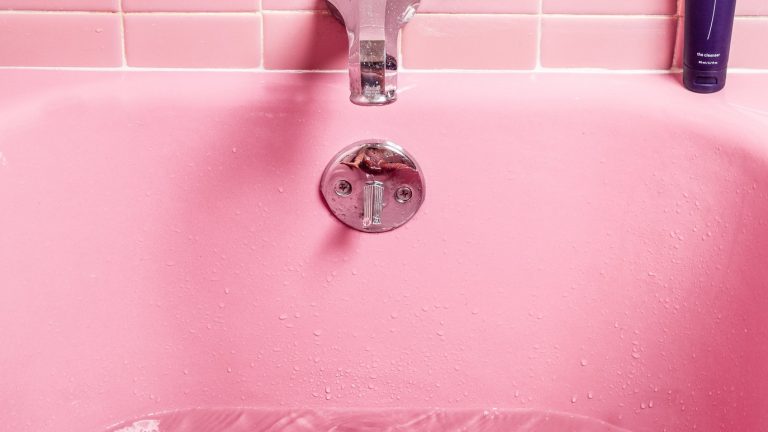 bath tub faucets in a pink bathroom